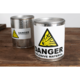 Metallbehälter mit Warnaufkleber "Danger Explosive Material" auf einem Holztisch. Ein weiterer Behälter ist im Hintergrund sichtbar.