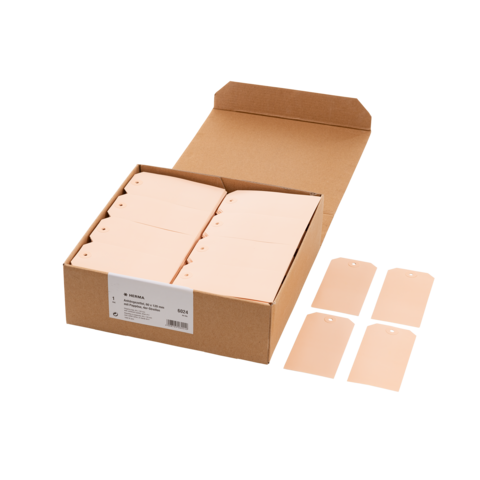 Eine offene Kartonbox mit mehreren rosa Etiketten und vier einzelnen Etiketten daneben.