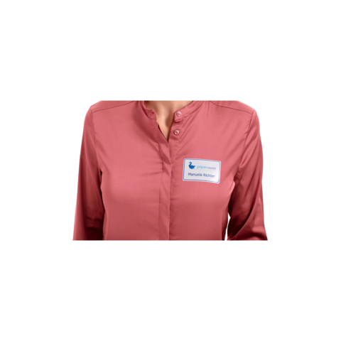 Eine Person trägt ein rosa Hemd mit einem Namensschild, auf dem "Manuela Richter" steht.