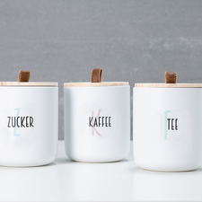 Drei Parfümflaschen, zwei mit dem Aufdruck "TESTER", eine mit rosa Flüssigkeit und eine mit gelber Flüssigkeit, stehen nebeneinander.