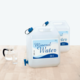 Zwei Kanister mit Mineralwasser, jeweils 20 Liter, stehen auf einem Tisch neben einem Glas und einer Karaffe.