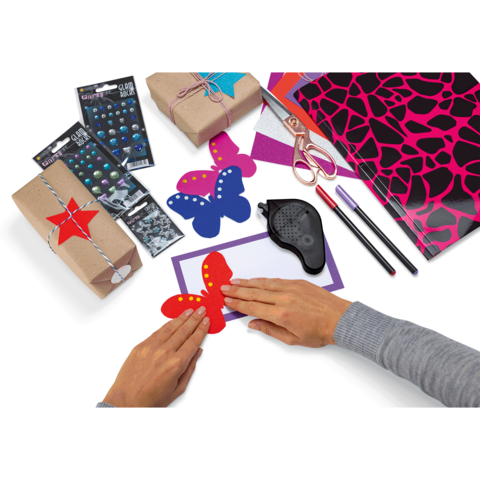 Bunte Bastelmaterialien, darunter Schmetterlinge aus Papier, Geschenke, Aufkleber und Stifte, liegen auf einem Tisch.