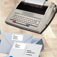 Kuvert med adressetiketter och en skrivmaskin