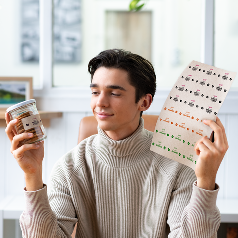 Ein junger Mann in einem eleganten Outfit hält einen Kaffeebecher und eine Mappe mit Dokumenten in der Hand, während er nachdenklich schaut.