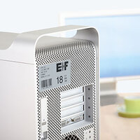 Silverfärgad inventarietikett på dator