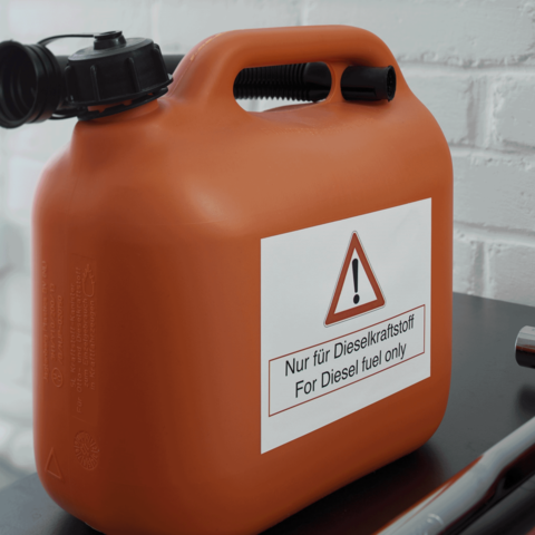 Oranger Kanister mit einem Warnschild, das besagt: "Nur für Dieselkraftstoff" und "For Diesel fuel only".