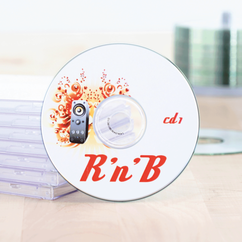 R'n'B CD mit dekorativem Design, beschriftet mit "cd 1", liegt neben transparenten CD-Hüllen auf einem Holzuntergrund.